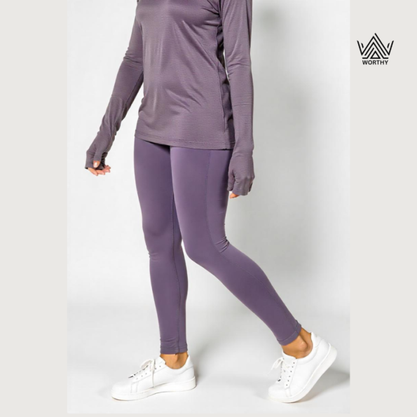 "Women's premium performance leggings in deep purple by Worthy Attire, styled with a matching top and white sneakers, perfect for activewear or casual streetwear." "Full-length women's purple leggings designed for comfort and flexibility, ideal for workouts and everyday wear by Worthy Attire." "Stylish and functional women's leggings in rich purple, paired with a casual top and sneakers for a trendy athleisure look." "High-quality breathable purple leggings for women by Worthy Attire, featuring a snug fit and durable fabric for versatile use." "Streetwear-inspired women's leggings in vibrant purple, crafted for fitness, yoga, or casual wear by Worthy Attire."